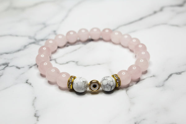 Beaded bracelet with pink, white, and gold beads on a white background